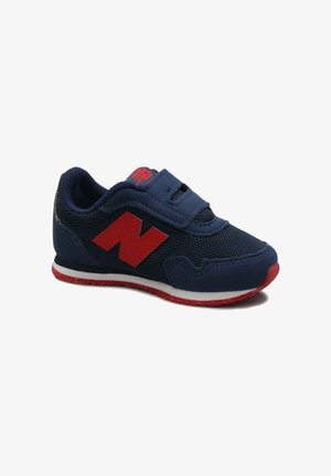 Scarpetta da bambino blu navy con logo "N" rosso, suola esterna rossa, intersuola bianca e chiusura con strap in velcro.