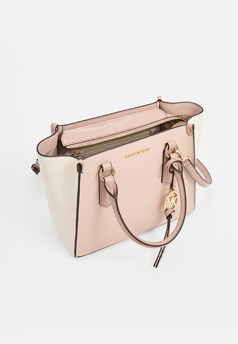 Tasche aus tanfarbigem und cremefarbenem Leder mit goldfarbenen Beschlägen, Reißverschluss, doppelten Griffen oben und einem Logo-Anhänger. Sie hat eine strukturierte Form und eine glatte Textur.