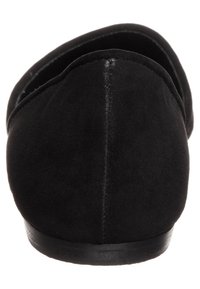 Mocassins en suède noir avec une texture lisse, un bout rond et une semelle noire basse. Design épuré, sans quincaillerie ni accents visibles.