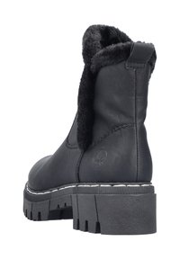 Czarny skórzany botek za kostkę z miękkim, futrzanym wnętrzem, pętelką z tyłu do łatwego zakładania, grubą czarną gumową podeszwą i białym przeszyciem jako detalem.