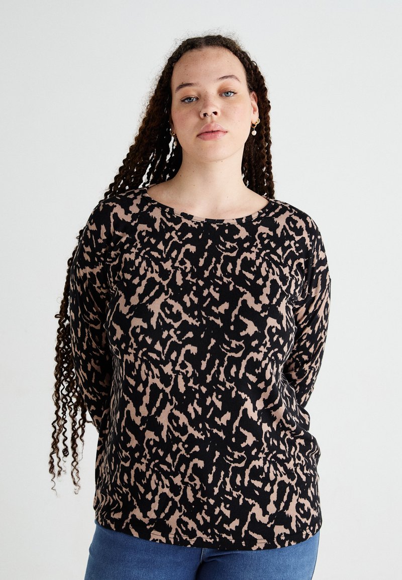 Svart långärmad topp med beige abstrakt djurmönster, rund halsringning och avslappnad passform. Tillverkad av ett mjukt, texturerat tyg.