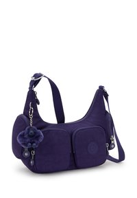 Bolso de hombro de nylon morado con dos bolsillos frontales con cremallera, correa ajustable y un llavero de pelo como acento. Textura suave con detalle del logo.