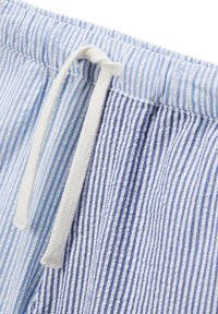 Shorts rayés en tissu coton de couleur bleu clair et blanc. Taille élastique avec cordon de serrage. Fini texturé avec des rayures verticales.