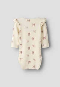 Vauvalkoinen vauvan body, jossa on ribatty pinta, pieniä vaaleanpunaisia nauhoja ja röyhelökoristeet olkapäillä.