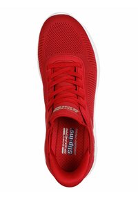 Red athletic shoe with a textured fabric upper, lacing system, and contrast white sole. Features a cushioned insole labeled "Memory Foam."