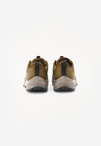 Brown athletic shoes with a textured fabric upper, padded collar, and rubber outsole, showing a gray midsole and black accents.