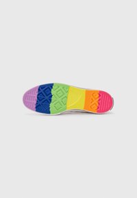 Flerfarget såle på sneakers med lilla, blå, grønn, gul, oransje og rosa seksjoner; teksturerte mønstre for grep og trekkraft.