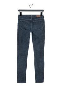 Vaqueros ajustados de denim en color azul oscuro, con una textura suave, cinco bolsillos y un parche de cuero en la cintura.