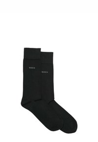 Calzini neri in cotone con bordo a coste e logo grigio "BOSS". Texture liscia e design alla caviglia. Stile classico e minimalista.