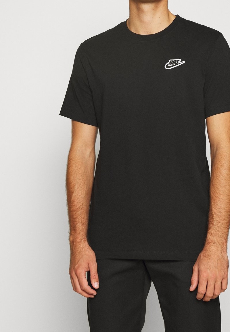 Svart bomullströja med rund hals och korta ärmar, med en vit Nike-logotyp på vänster bröstområde. Slät textur, vanlig passform.