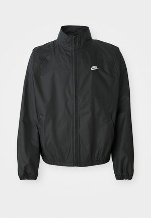 Black Nike zip-up windbreaker jacket with high collar, elastic cuffs, side pockets, and white Nike logo on chest.