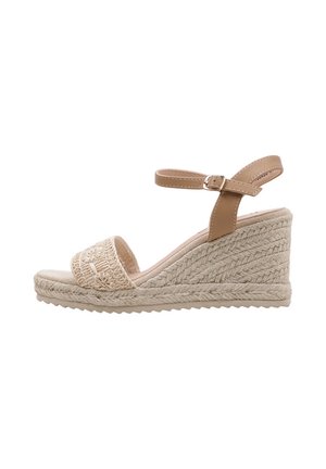 Sandalia de cuña beige con plataforma de yute tejido, tira abierta en el empeine y tira ajustable para el tobillo en tono cuero con hebilla plateada.