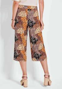 Gepofte culotte-broek met een patroon van een mix van oranje, bruin, zwart en crème met bloemen- en geometrische ontwerpen. Hoog in de taille en met wijd uitlopende pijpen.