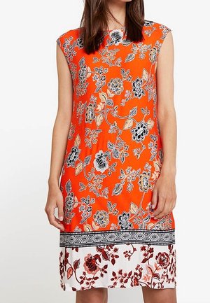 Pomarańczowa sukienka bez rękawów z czarno-beżowymi kwiatowymi wzorami, z białym kwiatowym obszyciem obramowanym czarną geometryczną lamówką.