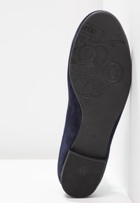 Semelle d'une chaussure en daim bleu foncé avec des motifs décoratifs embossés de pièces, nom de marque Kaiser et indication de taille 4 1/2.