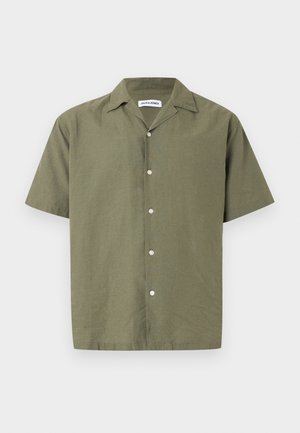 Camicia verde oliva a maniche corte in tessuto strutturato, con colletto piatto e sei bottoni bianchi lungo la parte anteriore.
