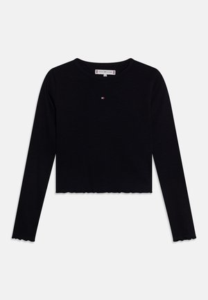 Sort langærmet cropped shirt med lille Tommy Hilfiger-logo centreret på brystet og subtile bølgede kanter på ærmerne og bunden.