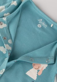 Türkiser Baumwoll-Overall für Babys mit Wolkenmustern, Druckknöpfen und einem bedruckten Schafdesign nahe dem Saum. Weicher Stoff, lässige Passform.