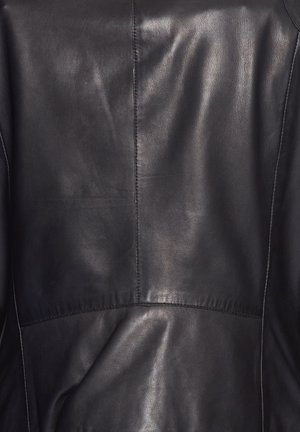 Zwarte leren jas met een gladde textuur; beschikt over een centrale naad en omgevouwen zoomdetails, wat de minimalistische ontwerpelementen benadrukt.