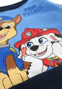 Sweatshirt bleu Paw Patrol avec un graphique de deux chiens dessinés, l'un en uniforme de police et l'autre portant un casque de pompier.