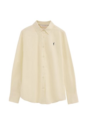Camisa beige de manga larga con botones y un pequeño logo de jugador de polo negro en el pecho izquierdo, corte ajustado con cuello clásico.