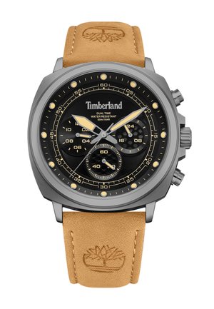 Montre à quartz avec un cadran noir, un boîtier argenté et un bracelet en cuir beige. Elle présente des fonctions de double fuseau horaire, un chronographe et le logo Timberland.