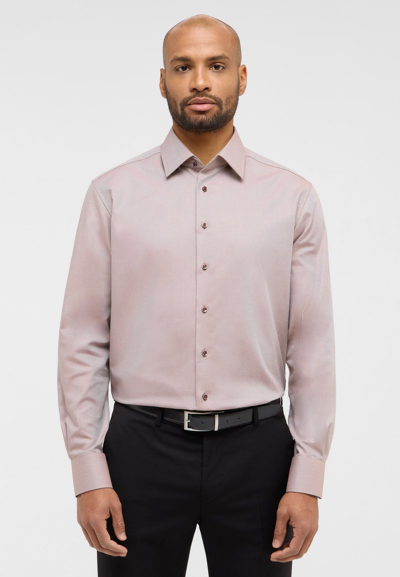 Lichtroze hemd met patroon, voorzien van een button-down kraag, lange mouwen en bruine knopen, gecombineerd met zwarte broeken en een riem.