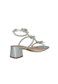Sandali alti argentati con tacco a blocco, caratterizzati da più sottili cinturini e decorati con strass. Finitura metallica liscia.