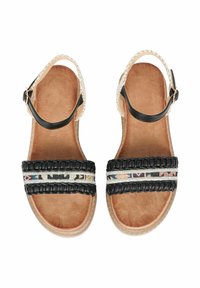 Sandali neri con cinturini intrecciati, dettagli decorativi in perline e una soletta color beige. Presentano un bordo intrecciato e una cinghia alla caviglia regolabile.