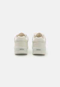 White sneakers with a textured leather upper, padded collar, and minimalistic design. Features gray accents and "ERADI" branding on the heel.