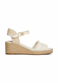 Sandalo con zeppa, in cima intrecciato beige, con accenti a righe bianche e una cinghia decorativa alla caviglia. Presenta una suola piattaforma avvolta in juta.