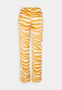 Spodnie w zebra, z żółtym i białym wzorem, wykonane z miękkiego materiału, z elastycznym paskiem w talii dla wygody i łatwości zakupu.