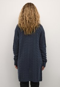 Lungo cardigan blu navy realizzato in tessuto a maglia testurizzata con motivo a zigzag, maniche lunghe e polsini a costine.