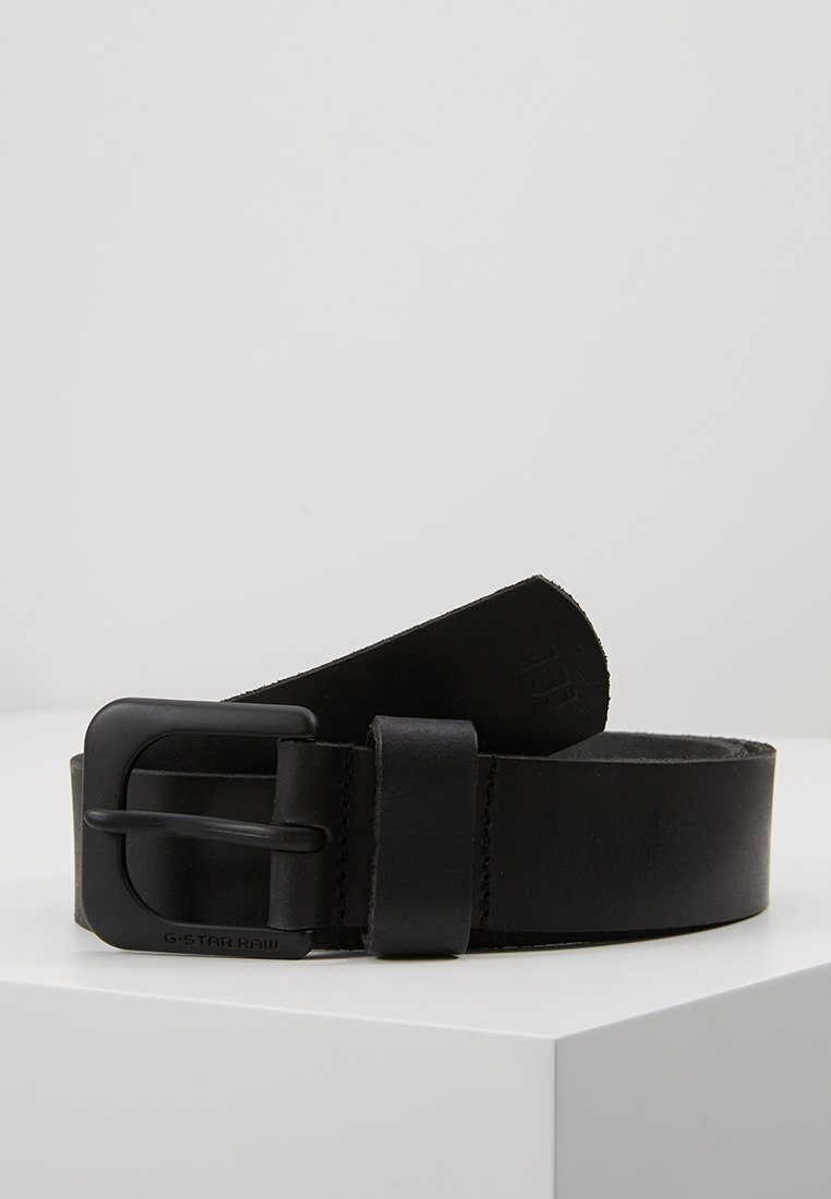 Schwarzer Leder Gürtel mit einer mattschwarzen Metallschnalle, die eine glatte Textur und ein sauberes, minimalistisches Design aufweist. Mit "G-STAR RAW" gekennzeichnet.