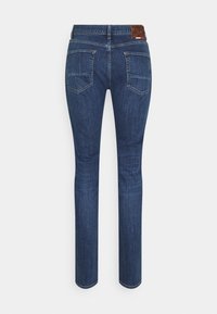 Úzké džíny z tmavě modrého denimu s hladkou texturou, vybavené dvěma zadními kapsami, koženou nášivkou na pásku a přiléhavým střihem.