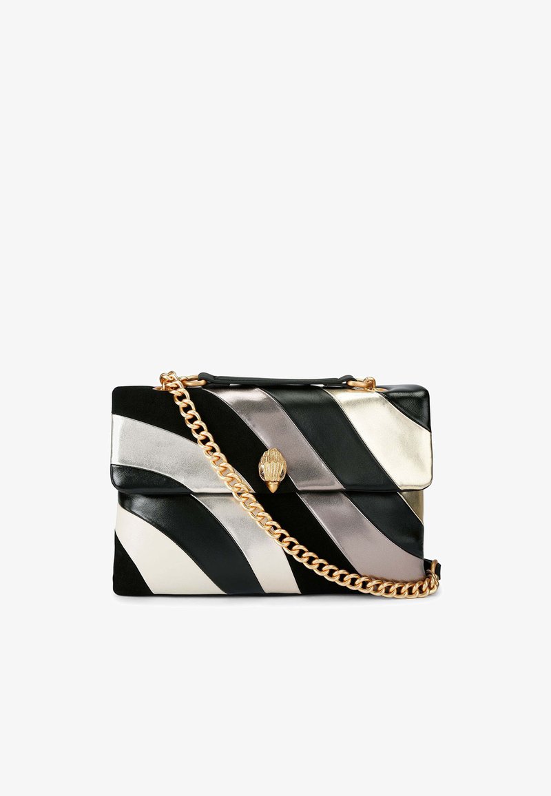 Bolso de mano de cuero en negro, blanco y plateado con rayas diagonales. Presenta una correa de cadena dorada y un cierre decorativo en la solapa.