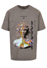 Grå, oversized t-skjorte laget av bomull med et Medusa-grafikk i sterke farger, med tekst i en moderne skrift på forsiden.