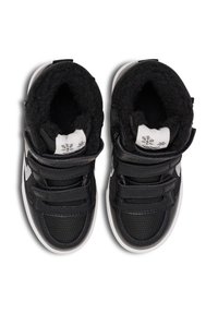 Sneakers alte nere con tomaia sintetica, cinturini in Velcro, morbido rivestimento nero e suola in gomma bianca. Presenta il logo sulla linguetta.
