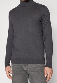 Mörkgrå tunn halströja i mjukt stickat tyg. Figurpassad design med långa ärmar och ribbad nederkant och ärmslut. Strukturerad yta.