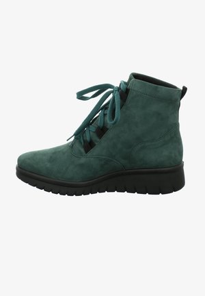 Bottine en daim vert foncé avec lacets à l'avant, col rembourré et semelle en caoutchouc noire épaisse dotée d'une traction rainurée.