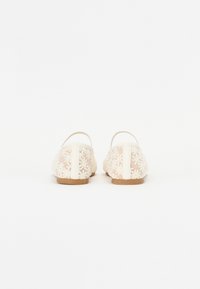 Ballerine in crema chiaro, con motivi floreali, punta arrotondata e suola in legno piatta per un comfort ottimale.