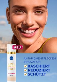 Nivea Luminous CC Fluid, weiße Flasche mit goldenen Akzenten, fördert die Anti-Pigmentierung, gekennzeichnet mit "neu", mit blauem Text auf hellen Hintergrund.