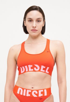 Červené dvoudílné bikini, které se skládá z sportovního crop topu se širokým logem a odpovídajícími vysokými kalhotkami, vyrobené z hladkého elastického materiálu.