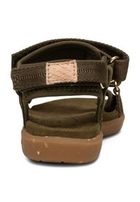 Olivgröna sandaler med justerbart rem, beige accentplatta och en brun gummisula. Mjuk fotsäng med en texturerad yta.