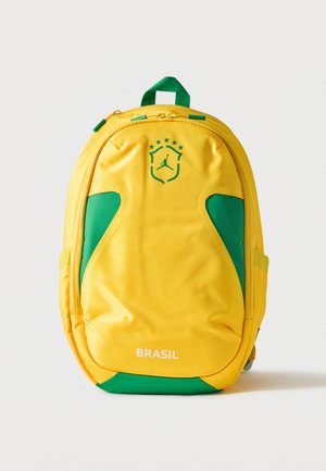 Kollane ja roheline seljakott Brasiilia logoga, millel on roheline kilp ja tähed üleval ning eesmisel taskul tekst "BRASIL".