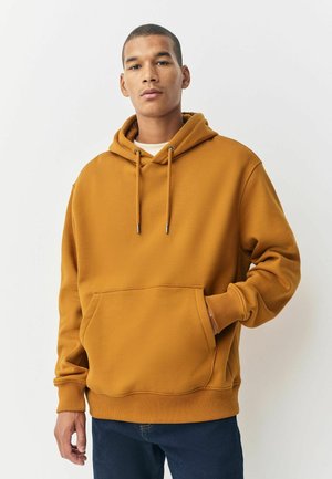 Mosterdgele hoodie met een voorzak, ribgebreide manchetten en een capuchon met trekkoorden. Gemaakt van een zachte stof met een gladde textuur.