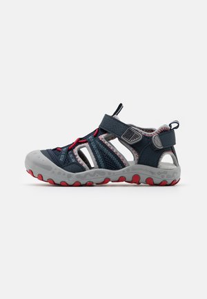 Sandale pour enfant bleu marine avec des accents gris et rouge, présentant des panneaux en maille, une sangle Velcro et une semelle texturée pour une traction améliorée.