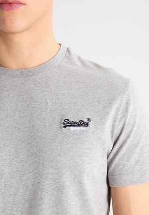 Grå bomulds t-shirt med rund hals og korte ærmer. Har et marineblåt broderet logo på brystet. Glat tekstur, afslappet design.