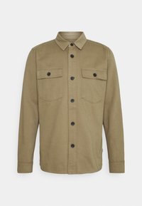 Zielona oliwkowa koszula na guziki z kołnierzykiem, dwoma kieszeniami na piersi i czarnymi guzikami. Wykonana z gładkiego, lekkiego materiału o prostym wzorze.