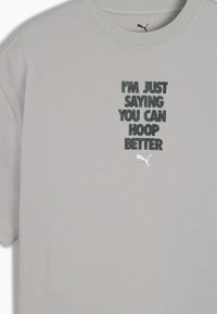 Camiseta de algodón de manga corta en gris claro con texto negro: "SÓLO DIGO QUE PUEDES JUGAR MEJOR" y un pequeño logo de Puma.